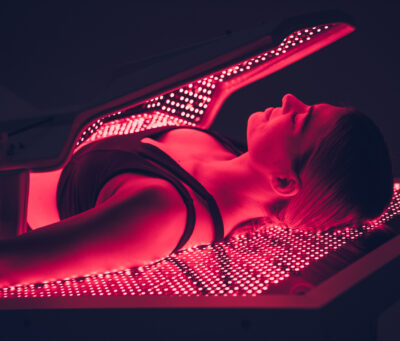 female model laying in lit bed-face view 1